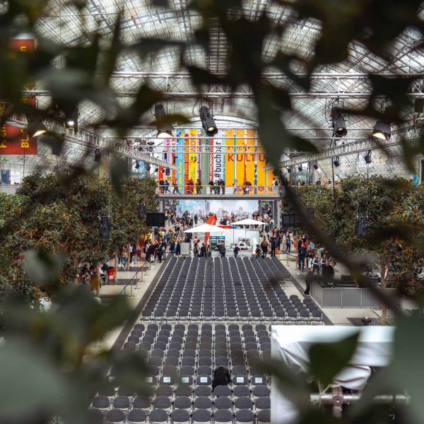 Ein Blick durch ein Geländer von oben auf eine Bühne und Stühle auf der Leipziger Buchmesse